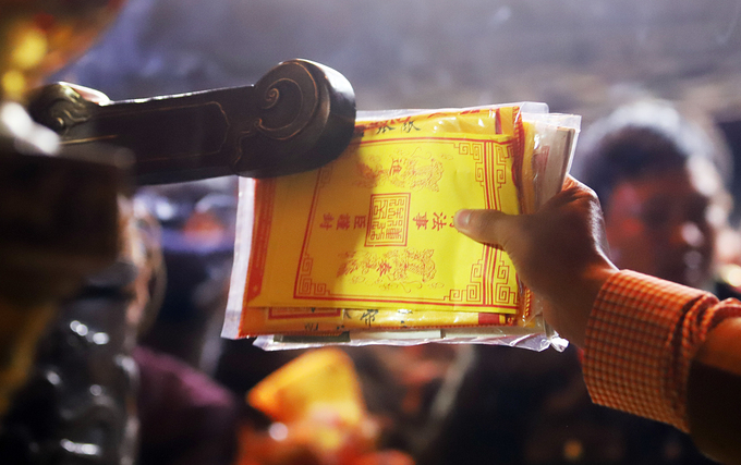 Dòng người xô nhau xoa tiền cầu may sau khai ấn đền Trần